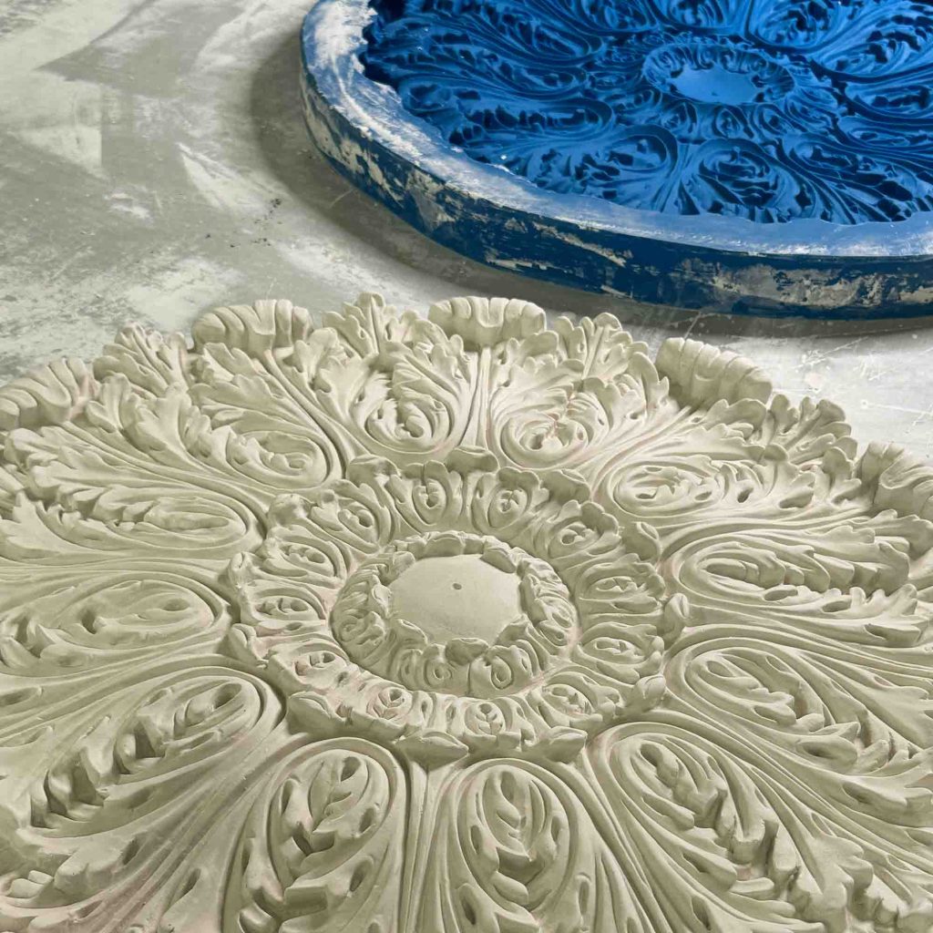 Bespoke plaster ceiling rose casting with intricate decorative detail in workshop