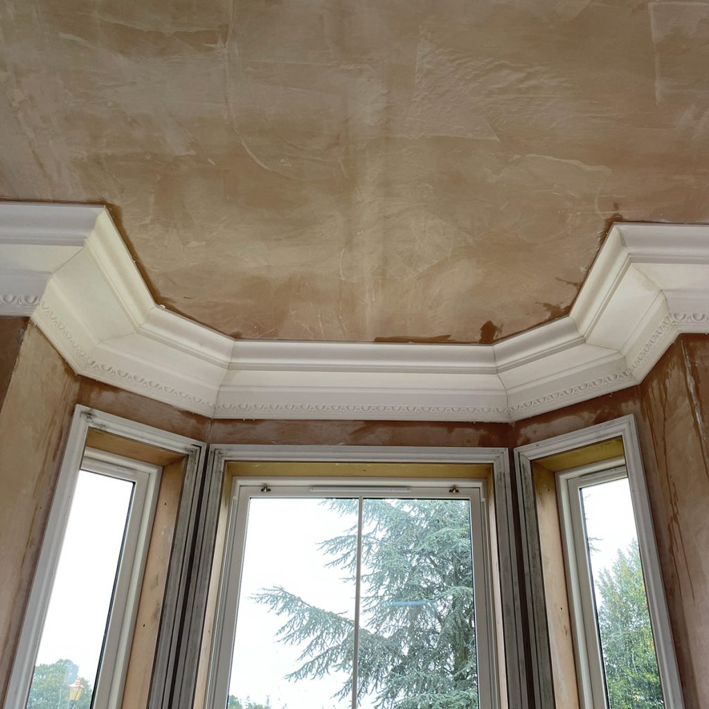 Plaster cornice installed around bay window with clean joints and consistent detail