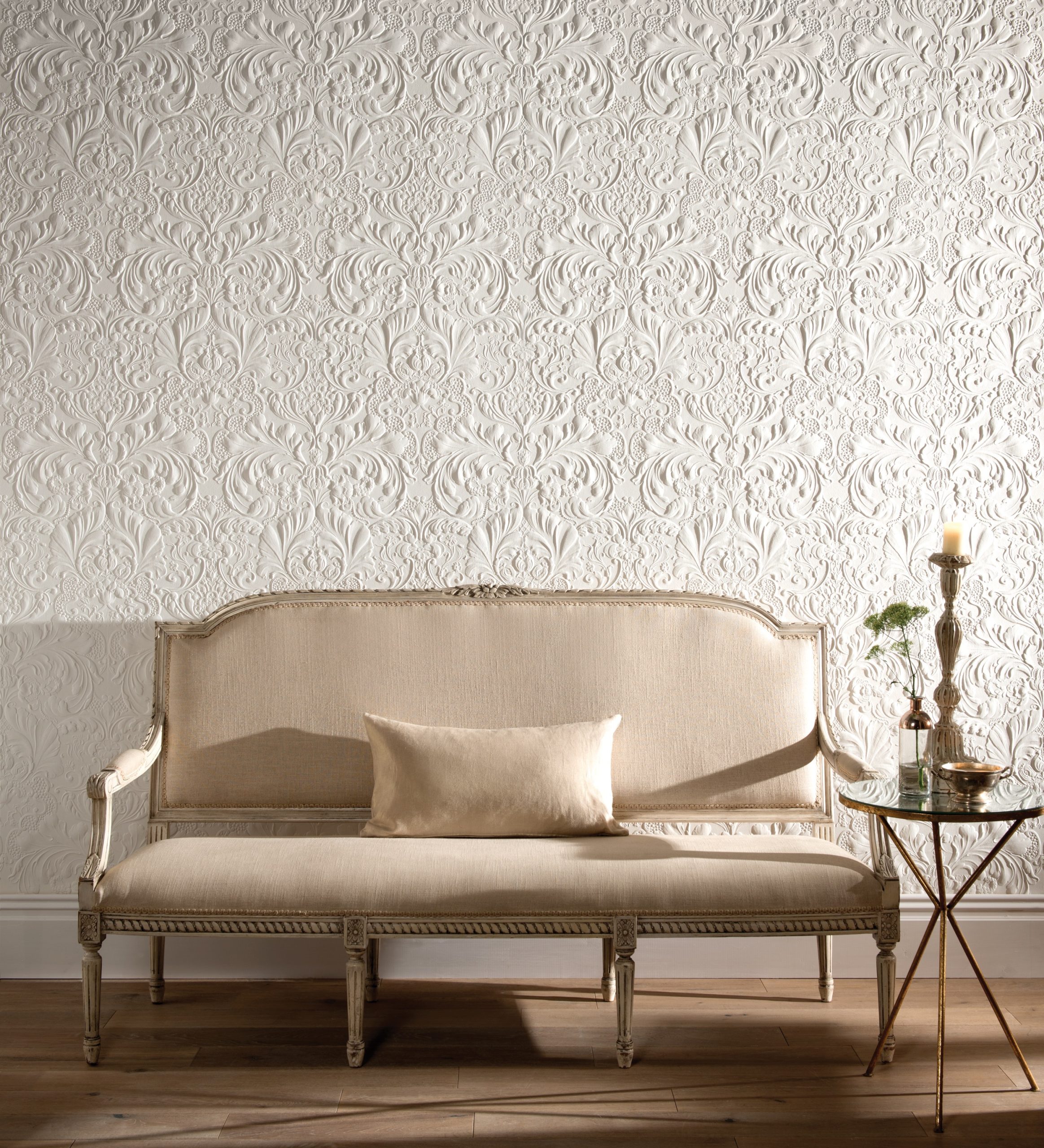 Lincrusta Italian Renaissance wallcovering behind elegant vintage sofa in luxury interior