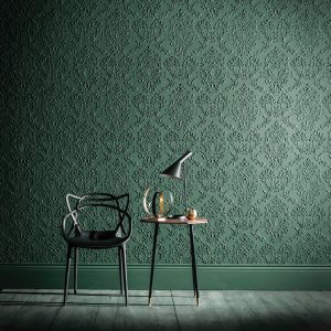 Lincrusta Green Damask Wallcovering – Embossed Luxury Wall Finish Green embossed Lincrusta damask wallcovering in a contemporary interior with black chair and side table