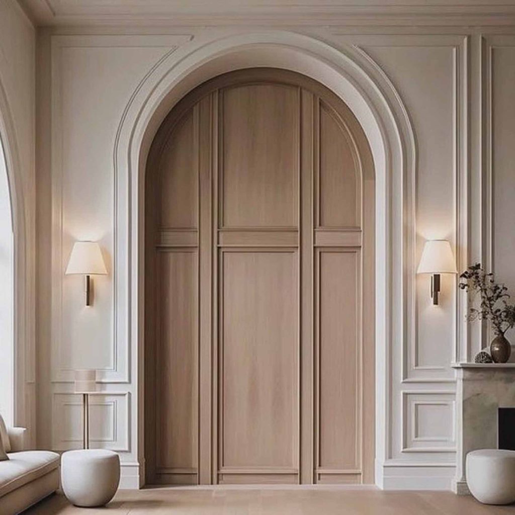 Elegant plaster arched doorway with decorative wall panel mouldings in a luxury traditional interior.