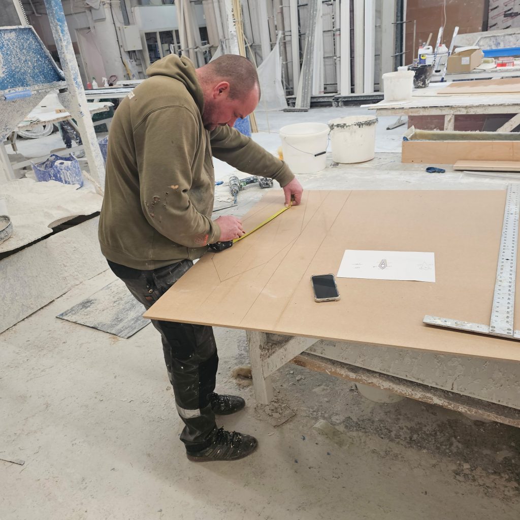 Craftsman marking out the Birmingham Central Mosque plaster ceiling design to scale in the workshop