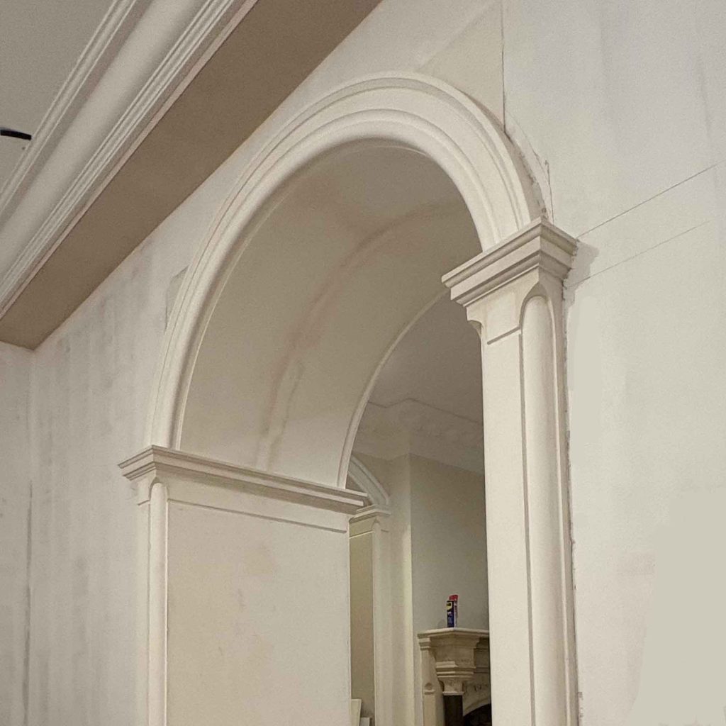 Handmade plaster archway with decorative columns installed in a period home