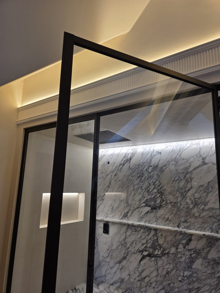 Bespoke fluted plaster uplighter installed above an en-suite shower in a Coventry property