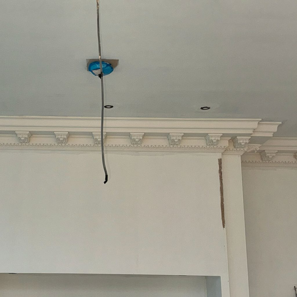 Finished enriched plaster cornice with decorative corbels in a Cobham home