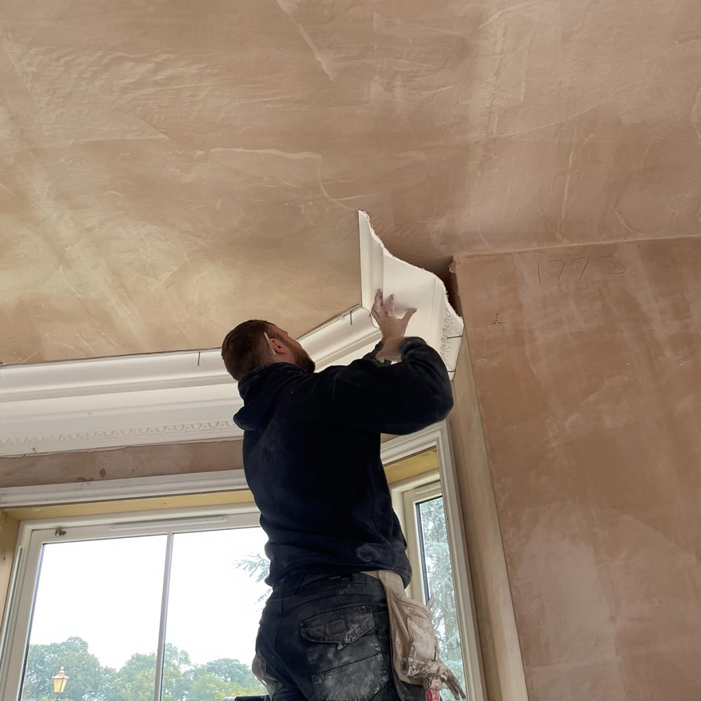 Plaster cornice being installed around a bay window in a Cheltenham property