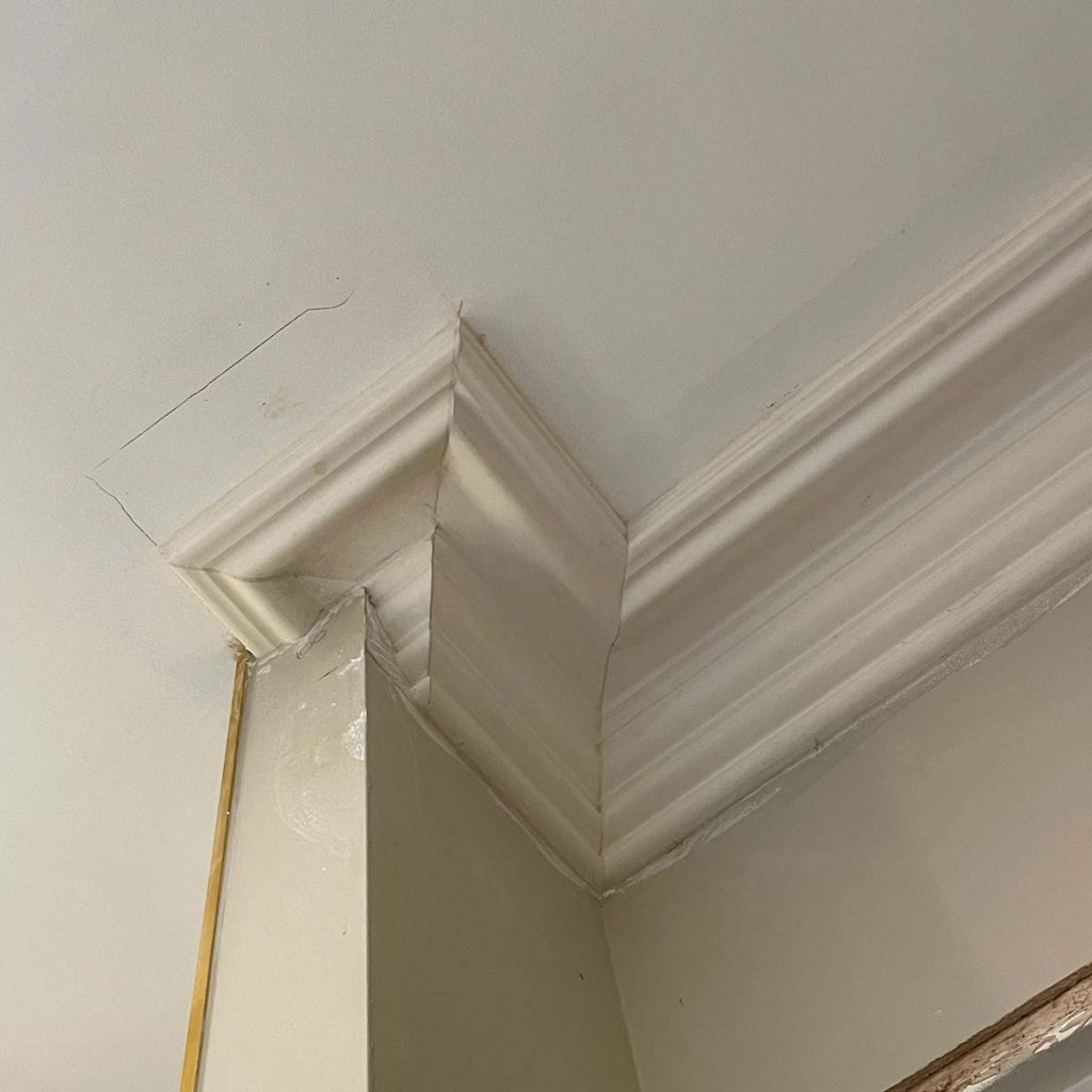 Detailed plaster cornice installation around a complex corner in a Worcester property
