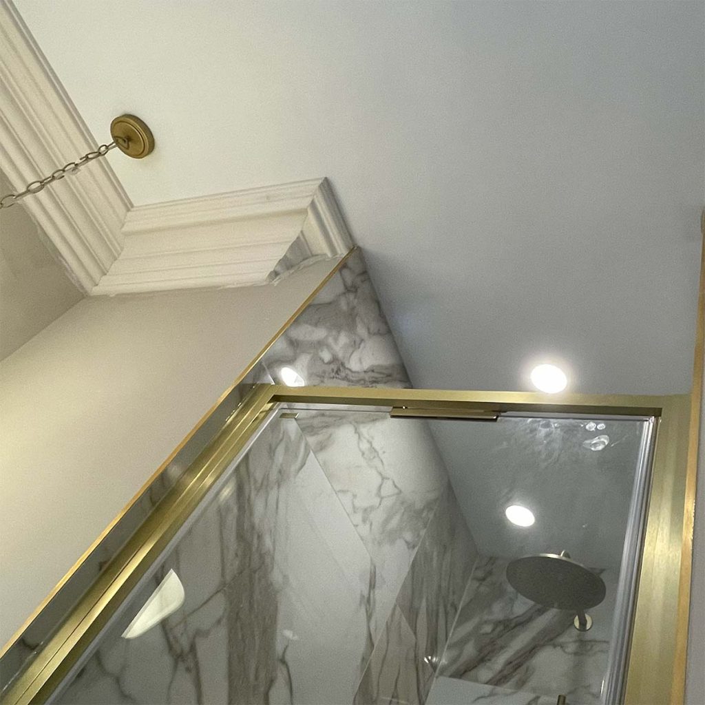 Plaster cornice fitted around a marble shower enclosure in a luxury Worcester bathroom